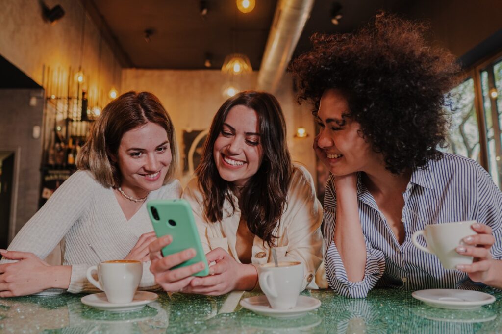 Three women checking their loyalty rewards program